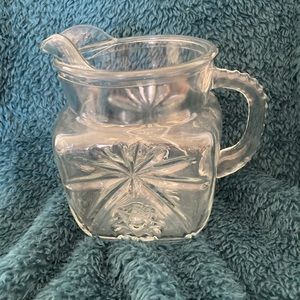 Vintage Anchor Hocking glass pitcher with starburst pattern and fluted handle.